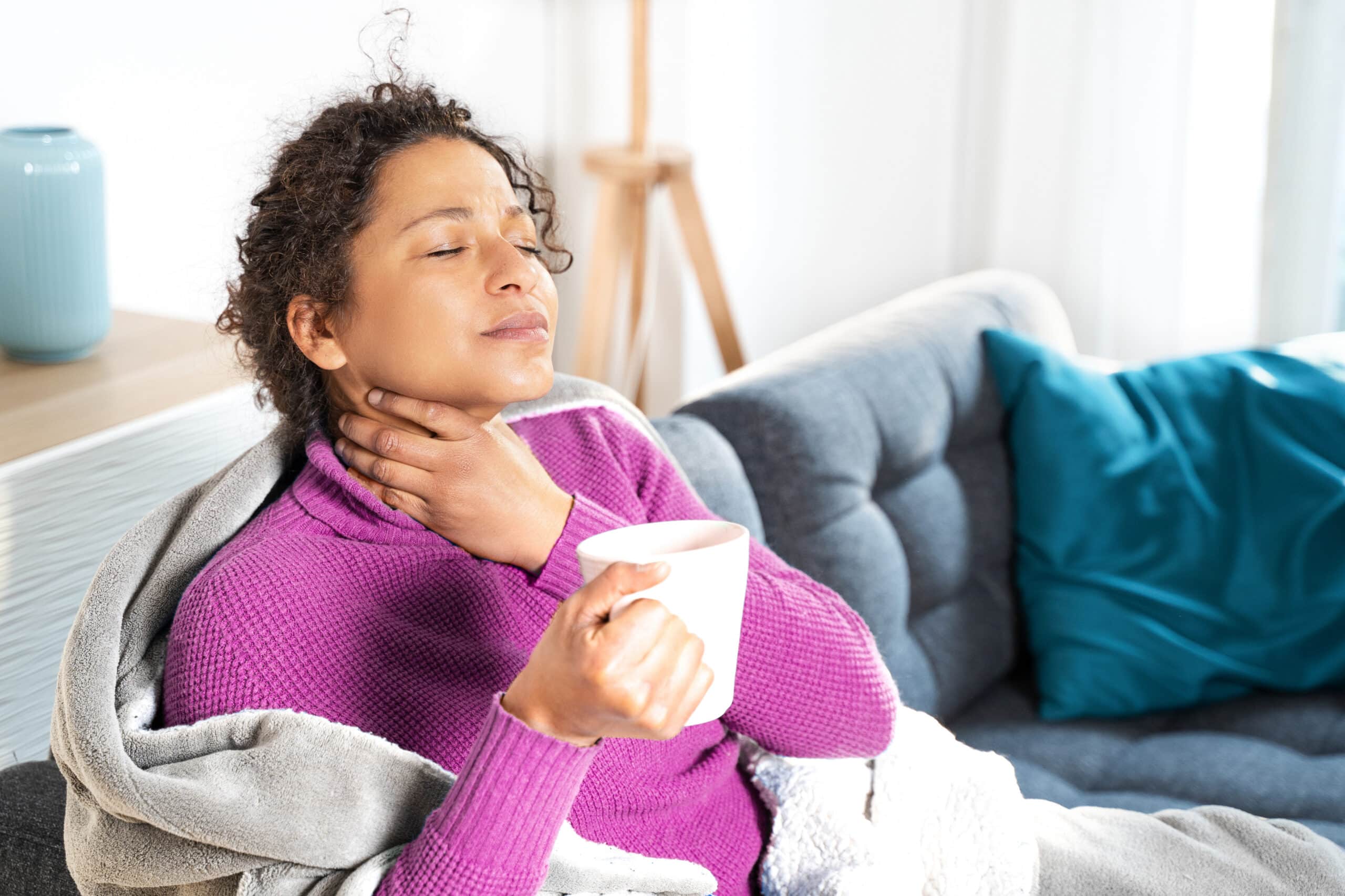 Portrait of black woman suffering sore throat at home